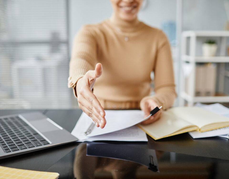 Close up of female HR recruiter stretching hand for greeting to camera in job interview, copy space